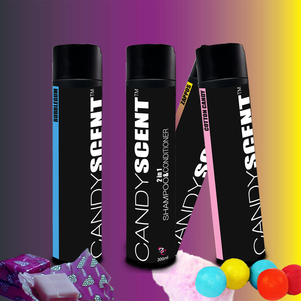 Image of three "CANDYSCENT™ 2 in 1 Shampoo & Conditioner" bottles on a colorful gradient background, featuring labels for "Bubble Gum," "Cotton Candy," and "Taffy." The bottles are lined up in a row with candy-related items such as bubble gum and taffy placed nearby, promising a silky finish.