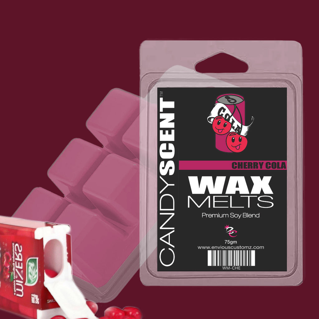 A package of CANDYSCENT™ Wax Melts in the Cherry Cola scent sits prominently in the foreground, adorned with a pink label and cherry cola illustrations. The vibrant pink cubes are highly scented for an immersive aroma experience. In the background, a partially melted candle and some red cherry candies add to the creation of a fragrant paradise.