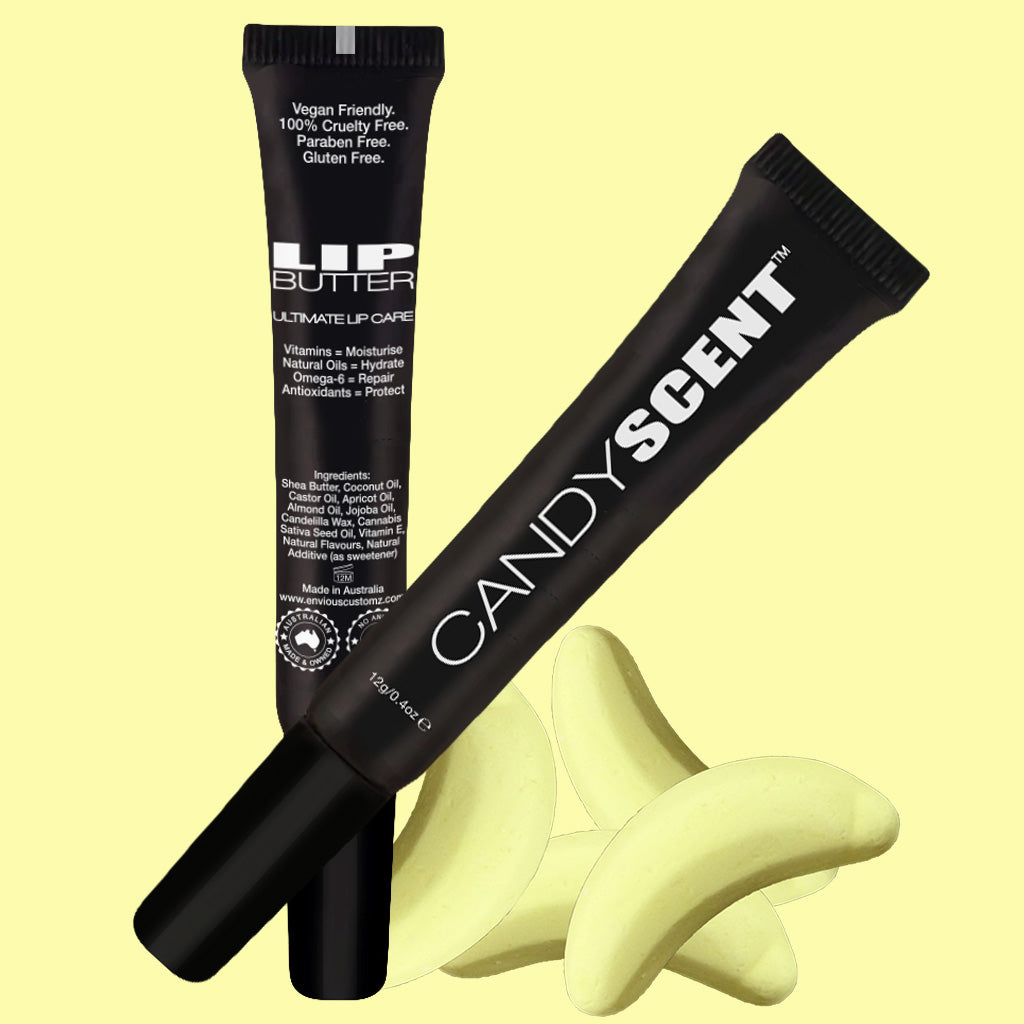 An image showcases two tubes of lip care products against a light yellow background. One tube is labeled "Lip Butter," emphasizing its moisturizing, natural ingredients, and the other bears the brand name "CANDYSCENT™." Adjacent to the tubes are three banana-shaped candies.