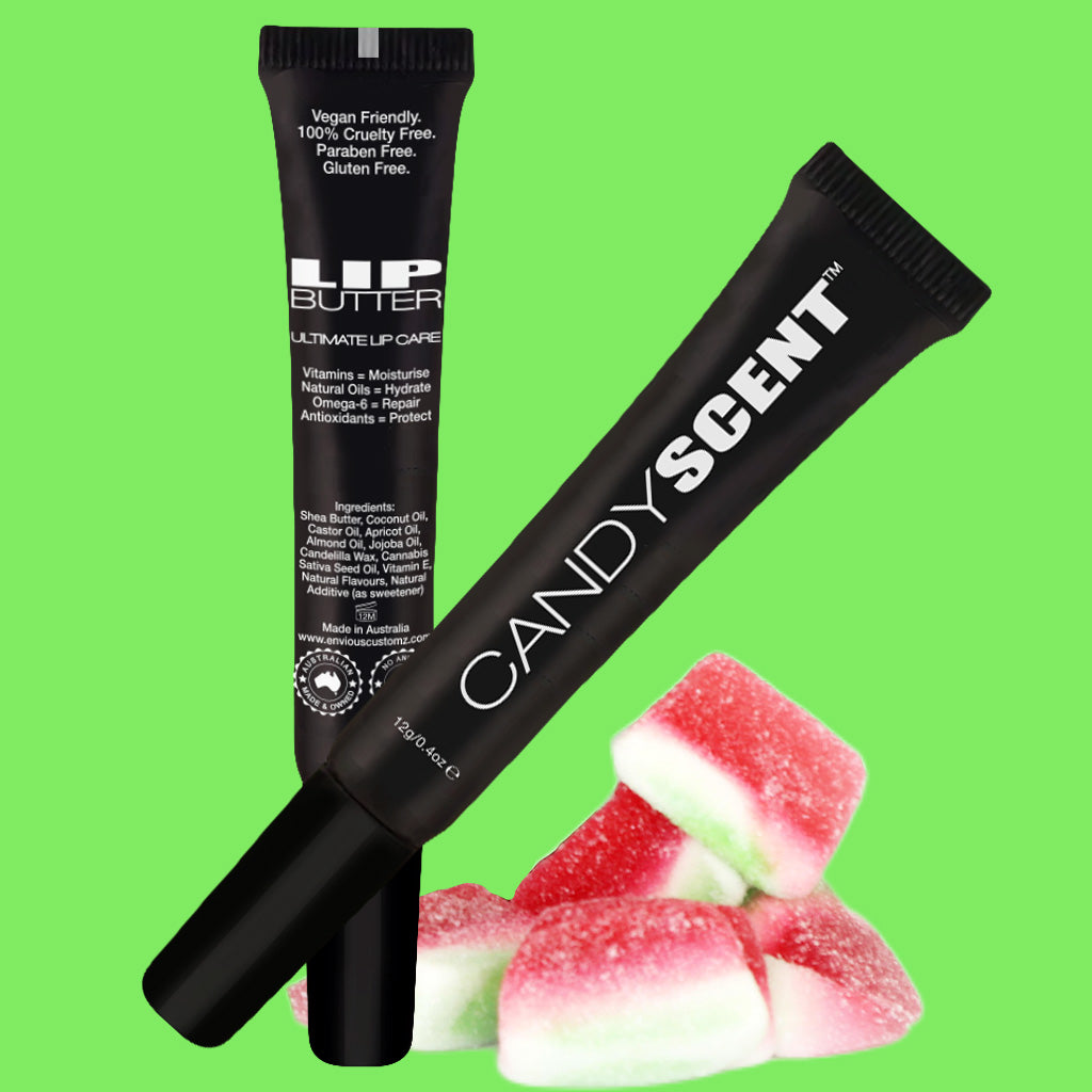 A product image featuring two black tubes of CANDYSCENT™ Lip Butter on a green background. The lip products, made with natural ingredients, are displayed alongside red and green gummy candies. The tubes highlight features like being vegan-friendly, cruelty-free, paraben-free, and gluten-free.