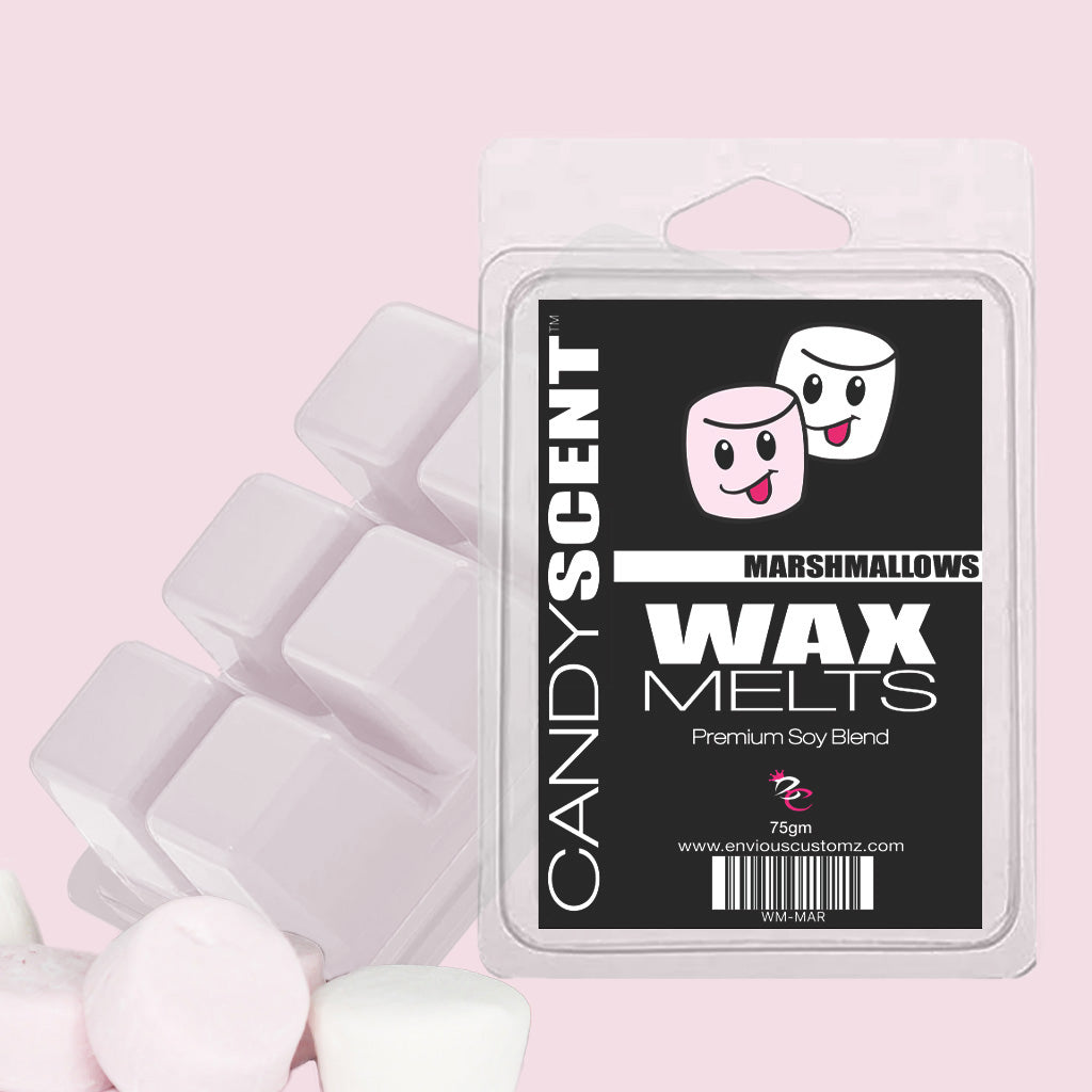 A package of CANDYSCENT™ Wax Melts, with its pink design and two cheerful cartoon marshmallows on the label, is surrounded by matching wax cubes and marshmallows, forming a delightful scented scene against a gentle pink backdrop.