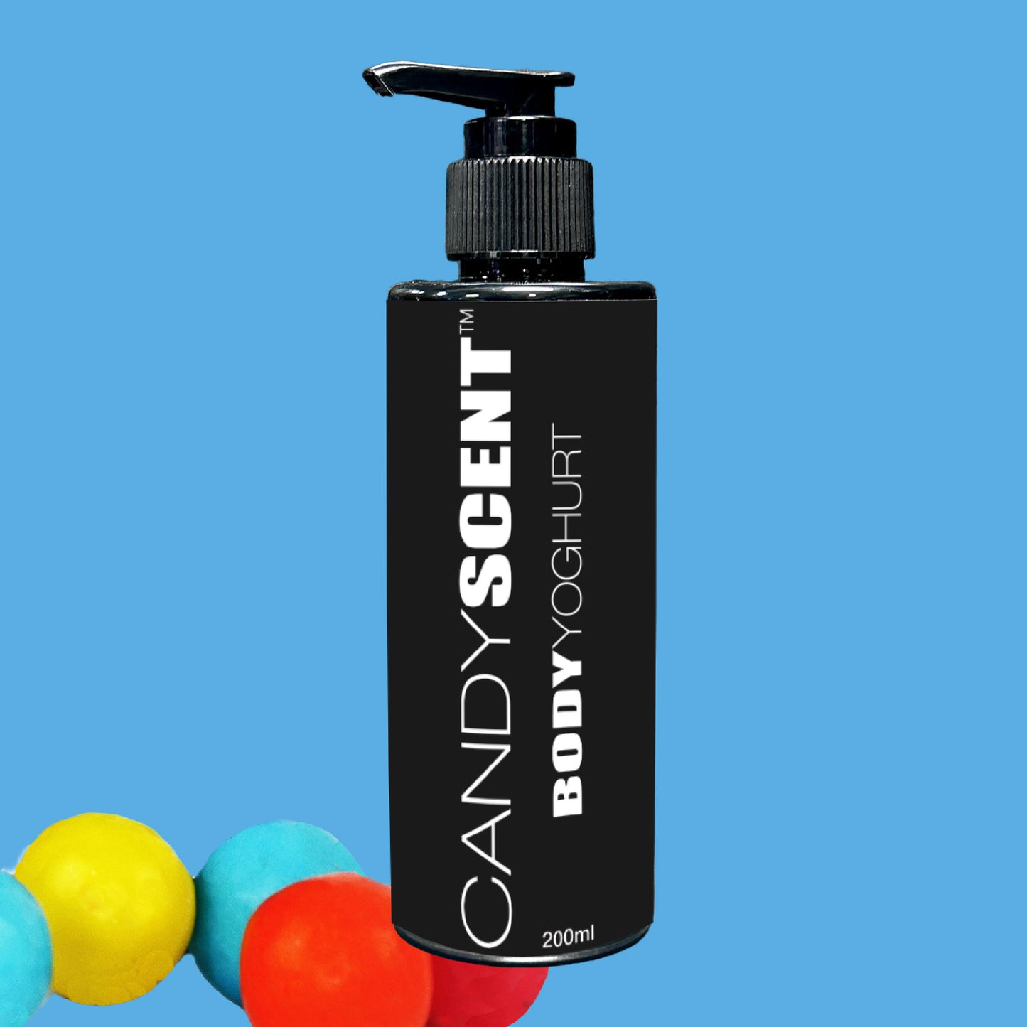 A black bottle of Body Yoghurt by CANDYSCENT™ featuring a pump dispenser is centered against a blue background. The bold, white text on the bottle invites you to experience deep hydration with this nourishing formula. Three colorful spheres—yellow, red, and blue—gracefully rest at the bottom left corner.
