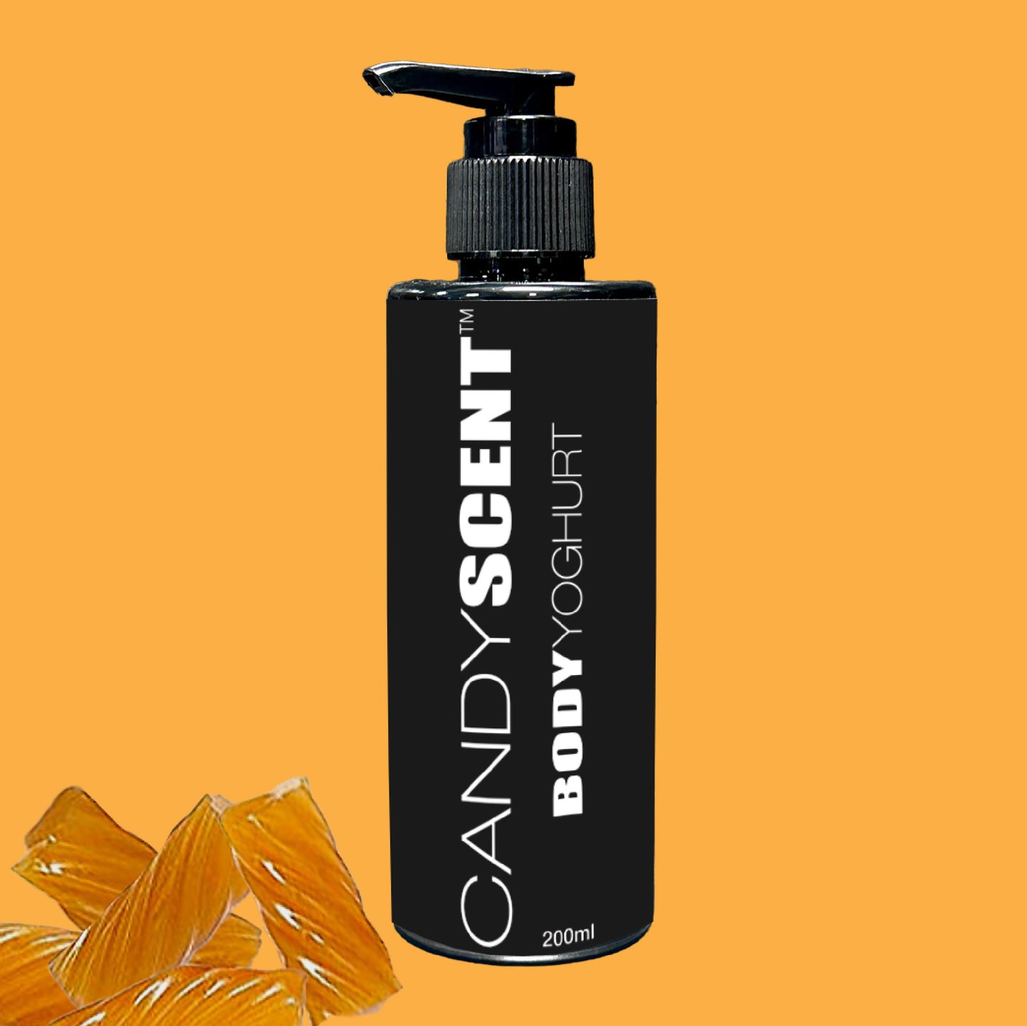 A black bottle labeled "Body Yoghurt" by CANDYSCENT™ featuring a pump dispenser is centered against an orange background, offering a nourishing experience. Two orange slice shapes are positioned near the bottom left corner. The 200ml bottle is perfect for deep hydration.