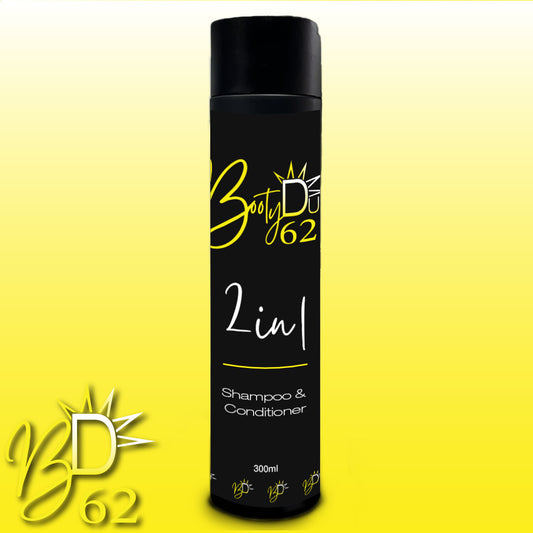 A black cylindrical bottle labeled "BOOTY DUPE 2 in 1 Shampoo & Conditioner" against a yellow gradient background. The bottle features white text for product description and yellow stylized branding with a sunburst design. This 300ml BOOTY DUPE Shampoo & Conditioner promises a soft and silky finish.