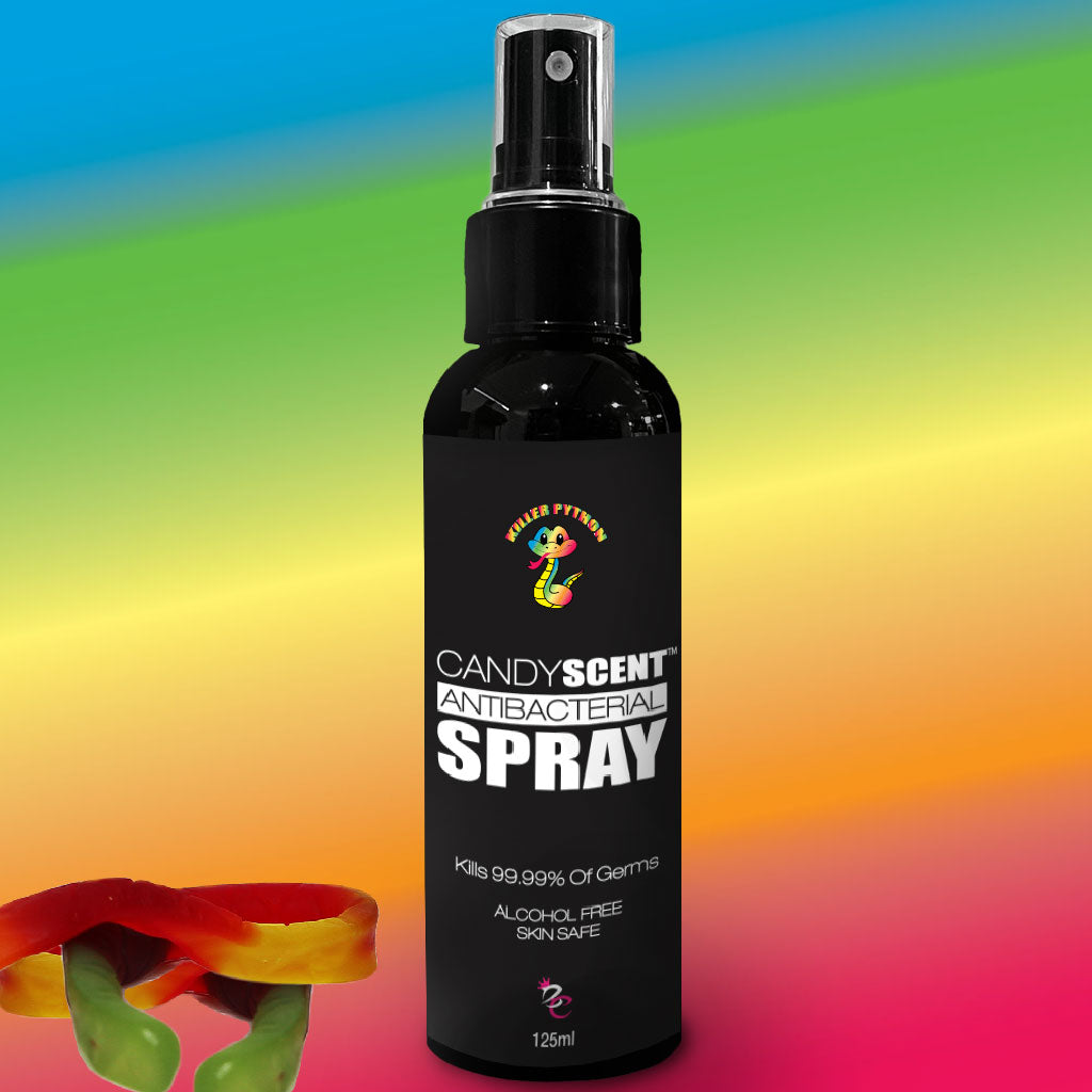 Image of a 125ml bottle of antibacterial spray branded "CANDYSCENT™" with "Candy Scent ANTIBACTERIAL SPRAY" in white text on a black label. This alcohol-free spray claims to kill 99.99% of germs. The colorful gradient background features gummy candies at the bottom.