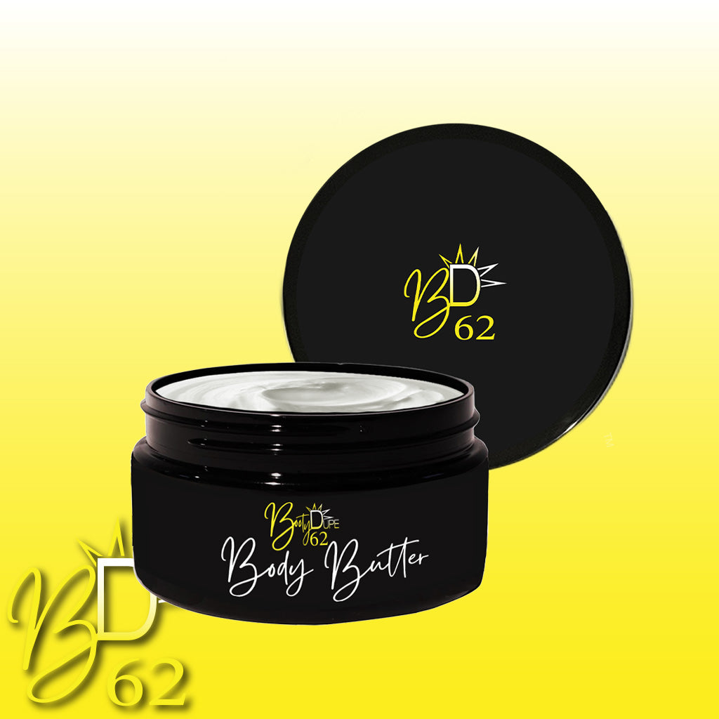 A black jar of BOOTY DUPE Body Butter with the lid off exposes the creamy, hydrating product inside. The label reads "B62" and "Body Butter," featuring a sun icon. The background showcases a gradient of yellow and white, suggesting deep nourishment.