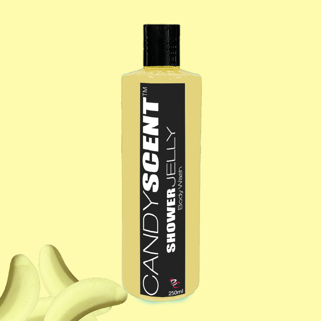 Against a pale yellow background stands an upright yellow bottle of CANDYSCENT™ Shower Jelly Body Wash, adorned with a black label featuring bold white and gray text. Complementing the vibrant theme are banana slices placed in the lower left corner. This 250 ml nourishing body cleanser promises a luxurious shower experience.