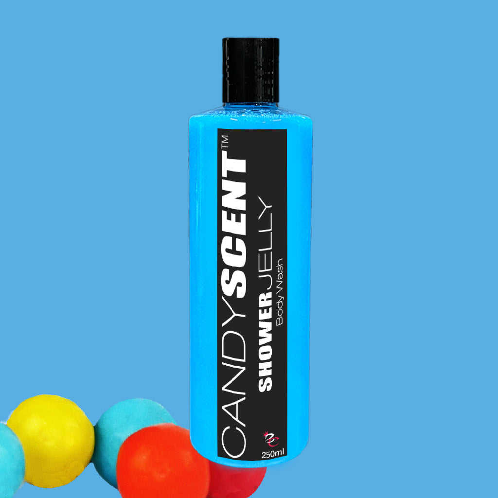 A blue bottle of CANDYSCENT™ Shower Jelly Body Wash with a black label and white text. The 250ml bottle stands against a solid light blue background, with colorful spheres in yellow, blue, and red partially visible at the bottom left corner.