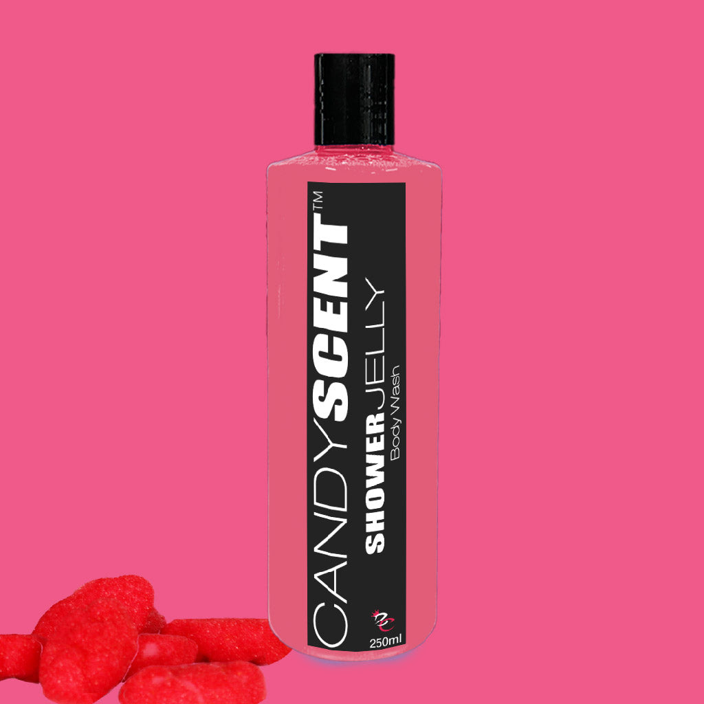 A 250ml bottle of CANDYSCENT™ Shower Jelly Body Wash with a pink liquid inside, set against a pink background. The black label reads "CANDYSCENT™ Moisturising Shower Jelly Body Wash." Red candy pieces are placed near the bottom left corner.