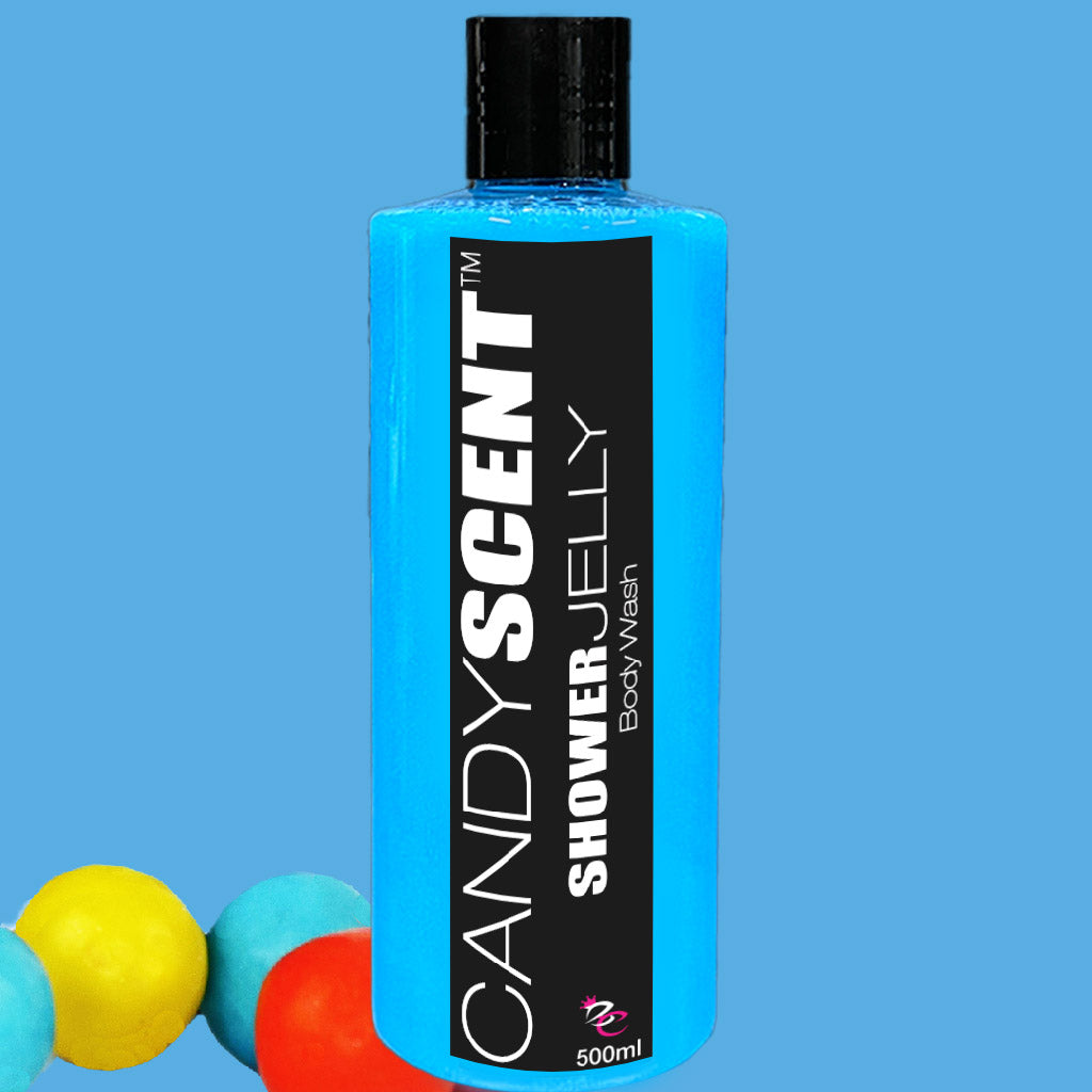 A blue bottle of "CANDYSCENT™ Shower Jelly Body Wash" featuring a black label with white text. The bottle has a black cap and contains 500 ml of moisturizing product. The background is blue, and there are colorful balls (yellow, blue, and red) in the bottom left corner.