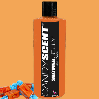 Photo of a 500ml bottle of CANDYSCENT™ Shower Jelly Body Wash with an orange label and black cap, set against an orange background. Three orange-wrapped candies lie at the bottom left corner, perfectly complementing the bottle's color.