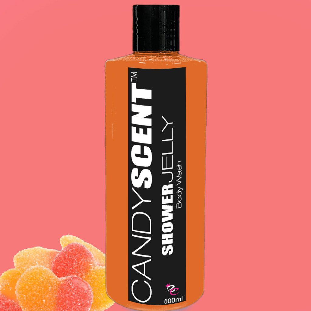 A 500ml orange bottle of CANDYSCENT™ Shower Jelly Body Wash with a black label and white text set against a pink background. The bottom left corner showcases colorful heart-shaped jelly candies.