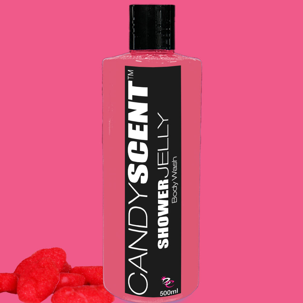 A bottle of CANDYSCENT™ Shower Jelly Body Wash is displayed. The pink bottle with a black label features the product name and contains 500ml of body wash. In the lower-left corner, a few red candy-shaped objects sit on a matching pink background.