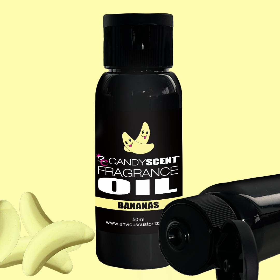 A small black bottle labeled "CANDYSCENT™ Fragrance Oil" with illustrations of two smiling bananas. The bottle, likely containing home scent fragrance oil, has a black cap and is positioned against a pale yellow background.