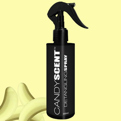 A black bottle of CANDYSCENT™ Hair Detangling Spray, equipped with a spray nozzle, stands against a light yellow backdrop. The 200ml bottle contains Aloe Vera, making it ideal for all hair types. Light yellow, curved shapes that appear like abstract plant leaves are partially visible in the background.