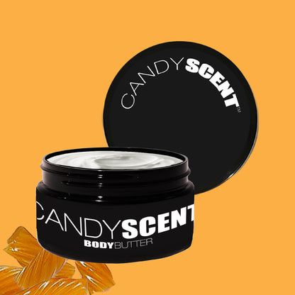 A black jar of CANDYSCENT™ Body Butter, with the lid removed, showcases its rich, nourishing texture against a warm mustard yellow background featuring a stylized orange peel design in the corner. It promises deep hydration for your skin.