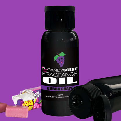 An image of a 50ml bottle of CANDYSCENT™ Fragrance Oil in Bubba Grape flavor, showcasing a label with a grape graphic. The sleek black bottle with a convenient flip-top cap is perfect for your oil burner and is set against a vibrant purple background. Nearby, some pieces of grape-flavored candy are visible, making for an ideal way to enhance your home scent.