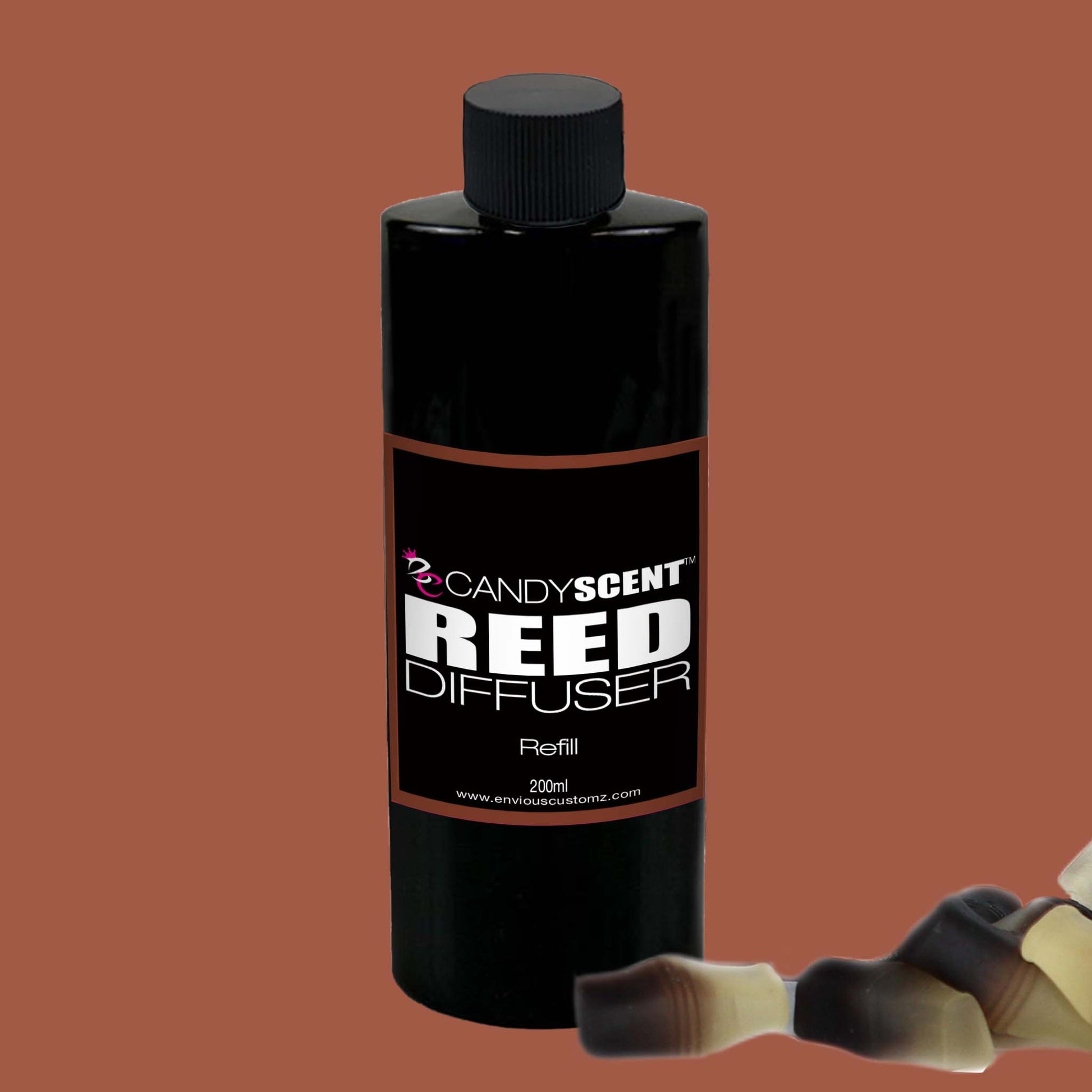 A black 200ml bottle labeled "Reed Diffusers & Refills" by CANDYSCENT™ is positioned upright against a brown background. In the foreground, there are a few reed diffuser sticks—one blurred to create depth. Proudly Australian made, this refill promises a long-lasting fragrance for your reed diffusers.