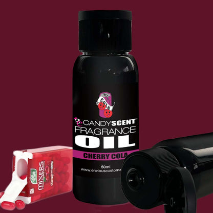 A bottle of CANDYSCENT™ Fragrance Oil, featuring a black label with red accents and cherry cola scent, is displayed prominently. To the side, a pack of cherry-flavored mints in a white dispenser is partially visible. The background is a solid maroon color, ideal for any stylish oil burner.