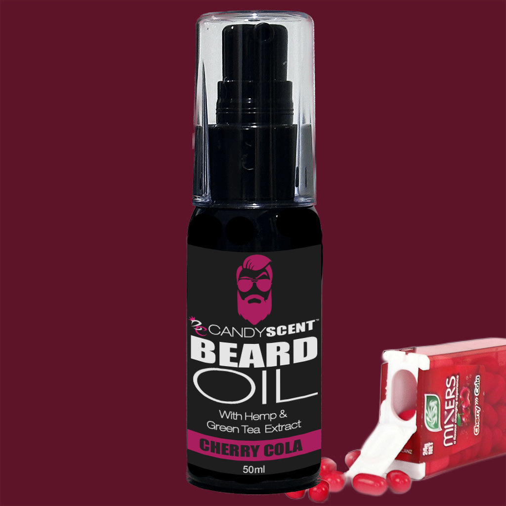 A bottle of CANDYSCENT™ Beard Oil in a Cherry Cola scent sits against a burgundy background. The black-labeled bottle, featuring a pink-bearded silhouette, touts hemp and green tea extract for beard health. Nearby is a pack of breath mints, possibly Tic Tacs—perfect grooming essentials for your daily routine.