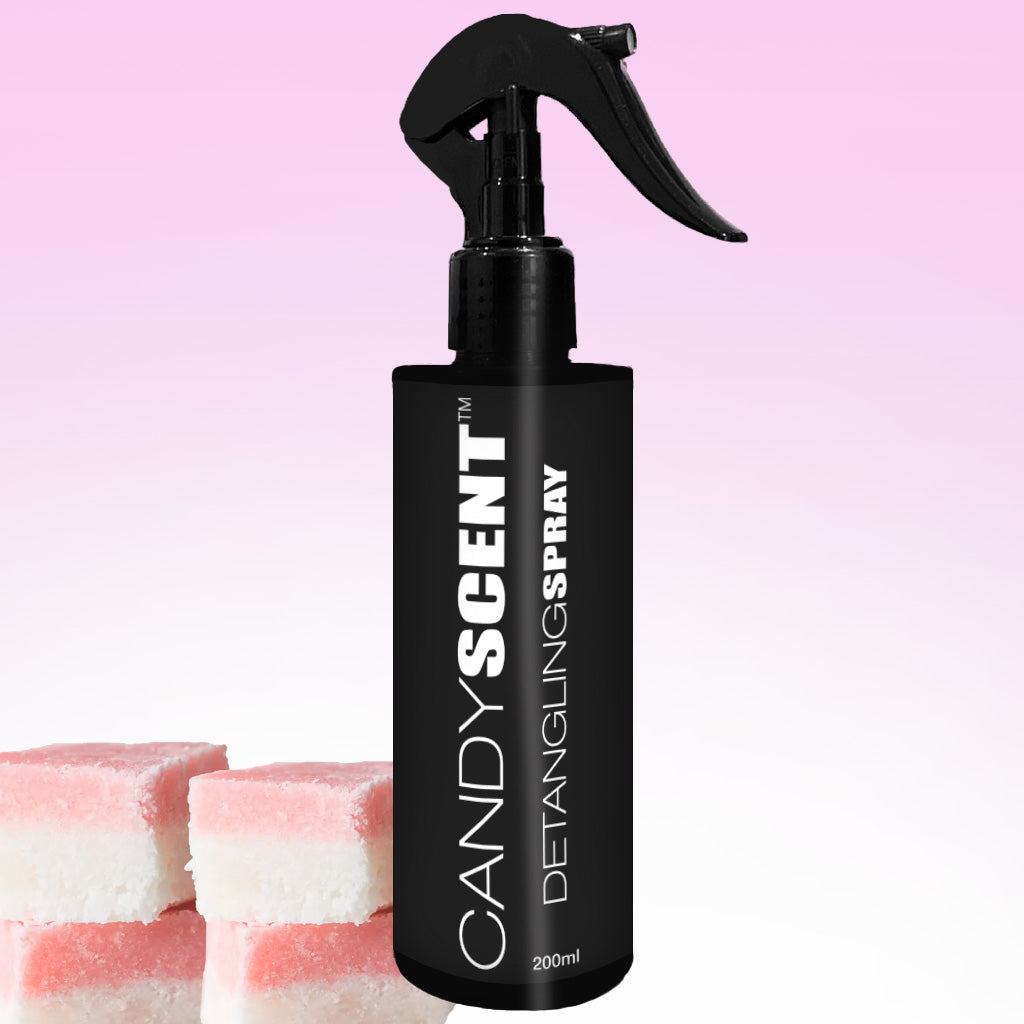 A black bottle labeled "CANDYSCENT™ Hair Detangling Spray" with a 200ml capacity and a spray nozzle is displayed against a gradient pink and white background. Three pink and white layered blocks, resembling candies, are positioned at the bottom left of the bottle.