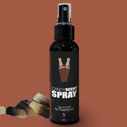 A black spray bottle of CANDYSCENT™ Car & Home Scent Sprays, labeled as a car and home air freshener, is displayed against a brown background. The bottle showcases an illustration of cola bottle candies and is equipped with a spray nozzle at the top. With a volume of 125ml, it promises to eliminate odors with its long-lasting fragrance.