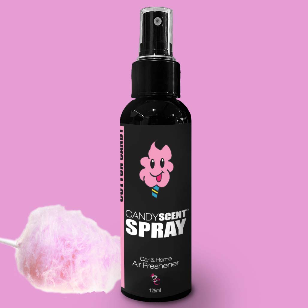 A black spray bottle labeled "CANDYSCENT™ Car & Home Scent Spray" with a cartoon picture of a smiling candy floss character. The label reads "CANDYSCENT™ Car & Home Air Freshener" and "125ml". Set against a pink background, the bottle is flanked by a cotton candy puff, promising to eliminate odors with its long-lasting fragrance.