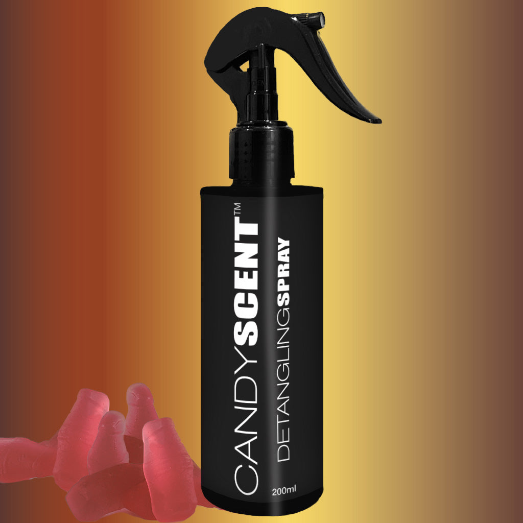 A 200ml black bottle of CANDYSCENT™ Hair Detangling Spray, infused with jojoba oil and aloe vera, is centered against a gradient background transitioning from yellow to brown. The bottle features a spray nozzle, with several abstractly placed red gummy bear candies at the bottom left.