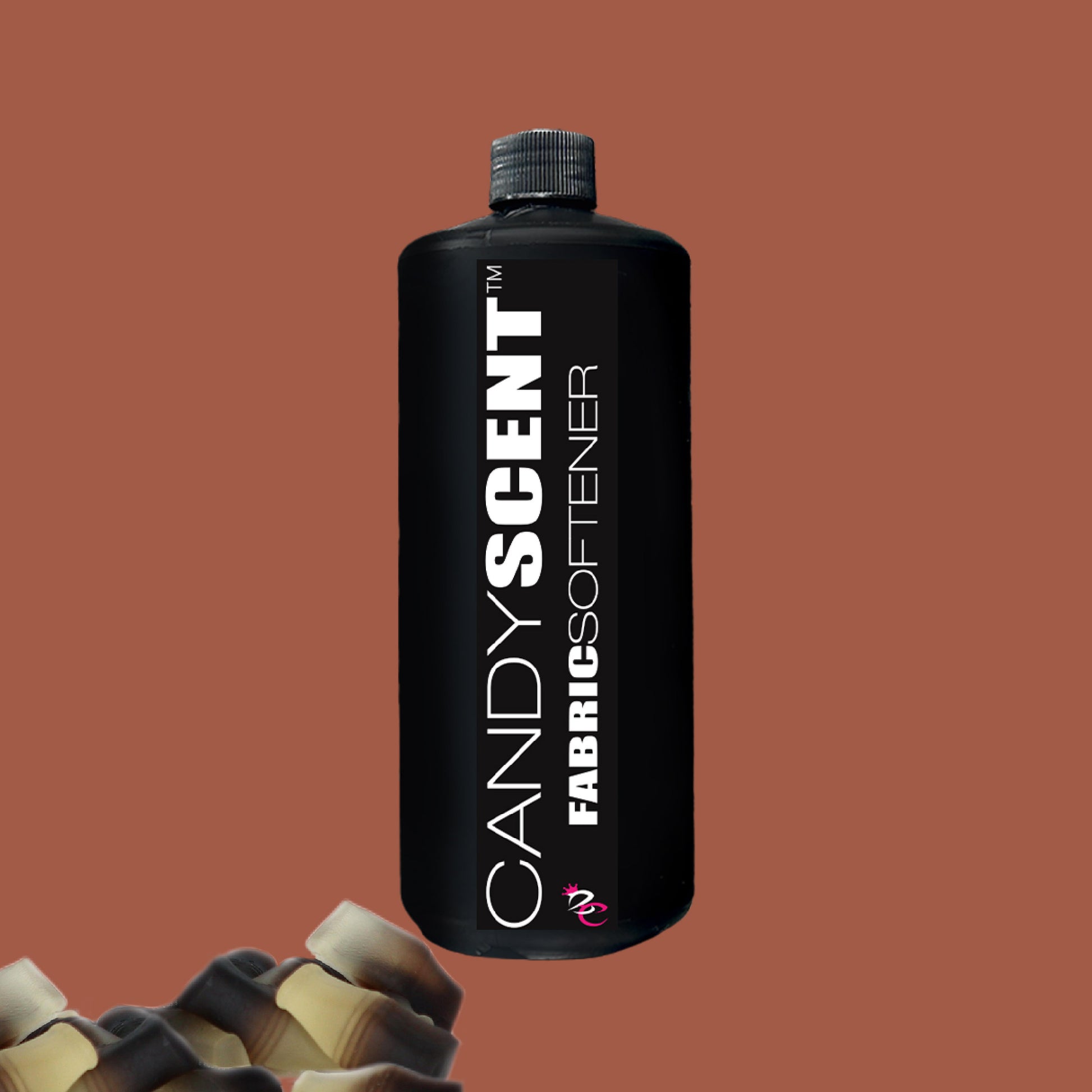 Against a brown background, a black bottle labeled "CANDYSCENT™ Fabric Softener" promises a wrinkle-free experience. The closed cap and bold label with contrasting colors stand out, with small parts of other bottle tops visible in the bottom left corner.