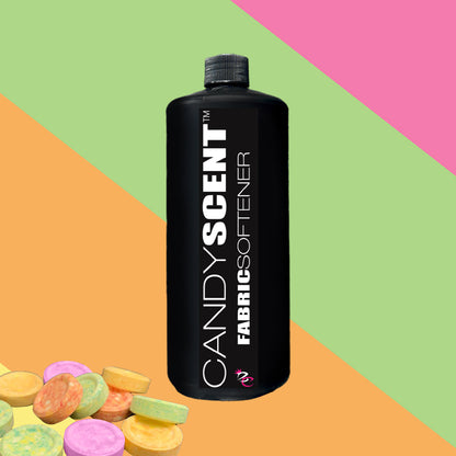 A black bottle of CANDYSCENT™ Fabric Softener sits at the center of a vibrant background featuring diagonal stripes in pink, green, and orange, boasting a wrinkle-free finish. In the bottom left corner, an array of colorful candy pieces adds to the playful ambiance.