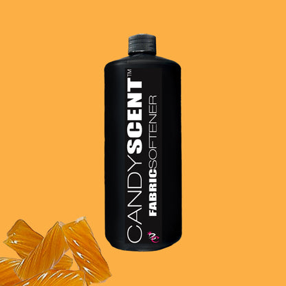 A black bottle labeled "Fabric Softener" from CANDYSCENT™ sits against a vibrant orange background, with several striped orange candy pieces visible in the bottom left corner, promising a static-free and wrinkle-free finish for your clothes.