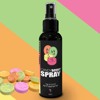 Introducing CANDYSCENT™ Car & Home Scent Sprays! A black spray bottle adorned with cartoon candy faces and labeled "Car & Home Scent Sprays" is centered. The spray is intended to eliminate odors and provide a long-lasting fragrance, holding 125ml for freshening both cars and homes. In the bottom left corner, colorful candy tablets stand out against a vibrant diagonal stripe background.