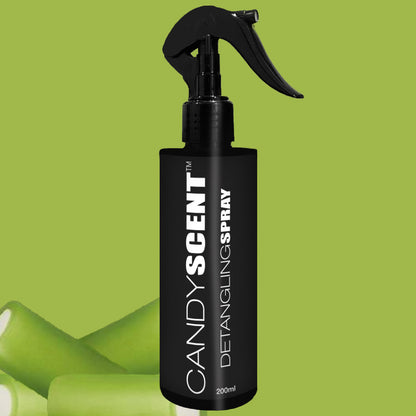 A black 200ml bottle of CANDYSCENT™ Hair Detangling Spray with a spray nozzle rests against a green backdrop, prominently displaying the text "CANDYSCENT™ Hair Detangling Spray" in white. The bottle features illustrations of aloe vera leaves at the bottom, suggesting its soothing ingredients.