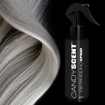 A close-up image showcases smooth, silver-blonde hair cascading gracefully down the left side. To the right, there's a black bottle labeled "CANDYSCENT™ Hair Detangling Spray 200ml" infused with jojoba oil and aloe vera, featuring a spray nozzle on top, all set against a black background.