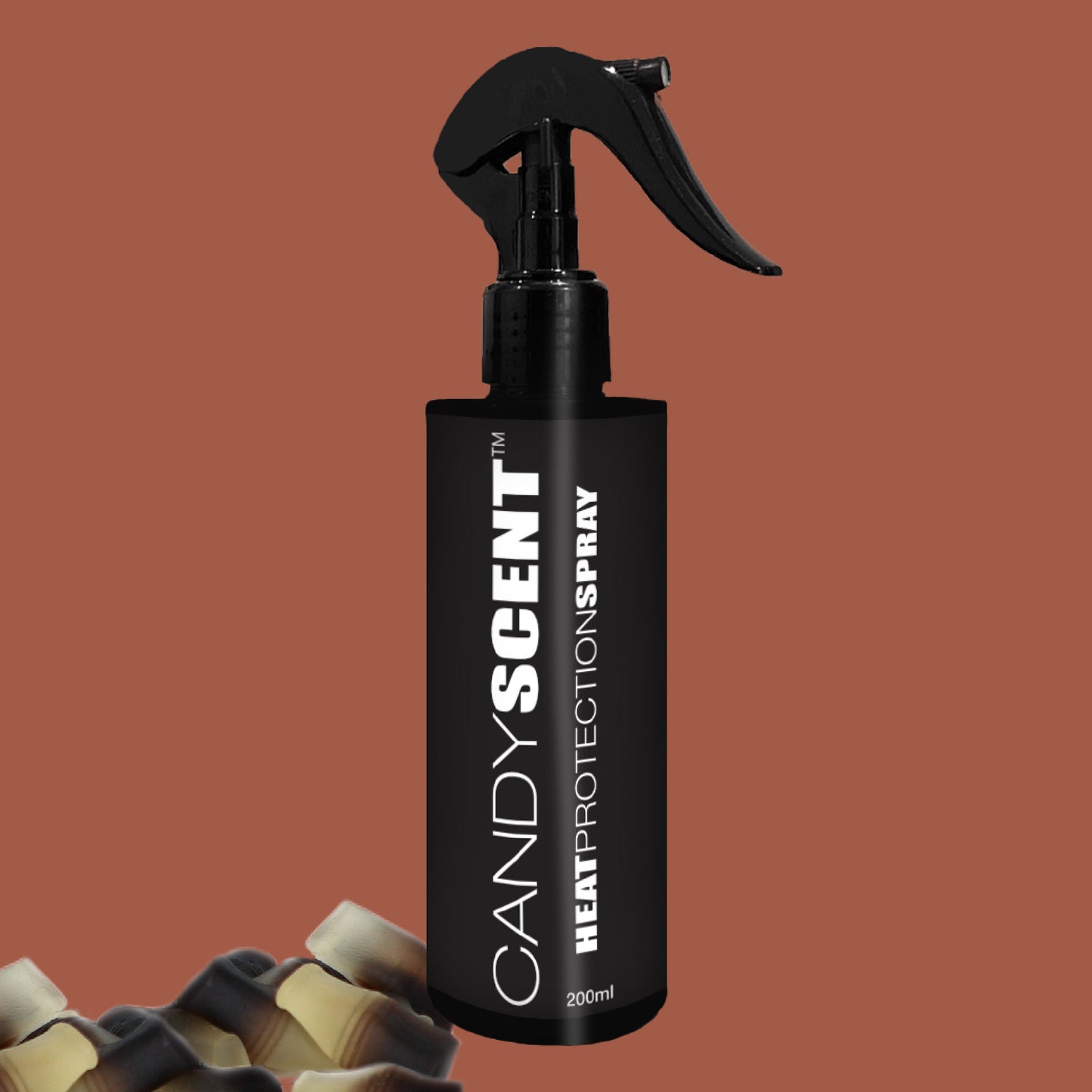 A black 200ml spray bottle labeled "CANDYSCENT™ Heat Protection Spray" is set against a brown background. The bottle, complete with a trigger nozzle for effortless use, offers salon-quality results. In the lower corner, small bottles with beige caps can be seen partially.