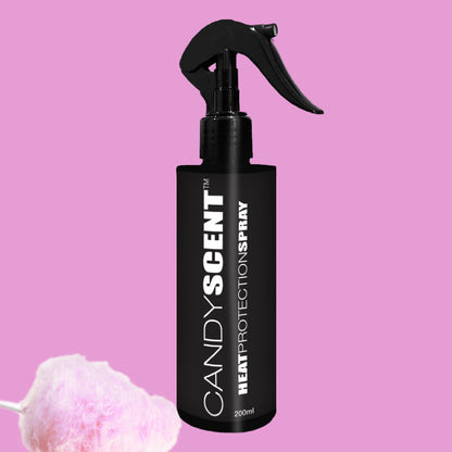 A sleek black bottle of CANDYSCENT™ Heat Protection Spray stands against a pink background, offering professional-grade results. Its "CANDY SCENT" label suggests the sweetness evoked by the pink cotton candy placed in the lower left corner.