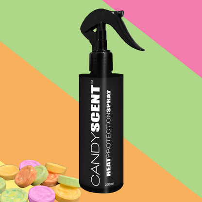 A black bottle with the label "CANDYSCENT™ Heat Protection Spray" stands on a vibrant, striped background. Pastel-hued candy pieces add a playful element to the scene, offering salon-quality hair protection.