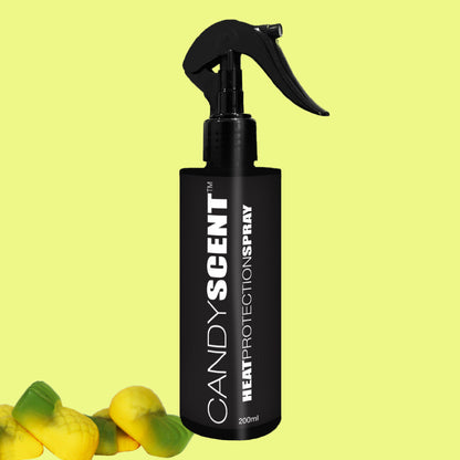 A black bottle of CANDYSCENT™ Heat Protection Spray, complete with a spray nozzle, stands against a light yellow background. The bottom left corner is adorned with vibrant, candy-like objects, adding a playful touch and promising to strengthen hair with every spritz.