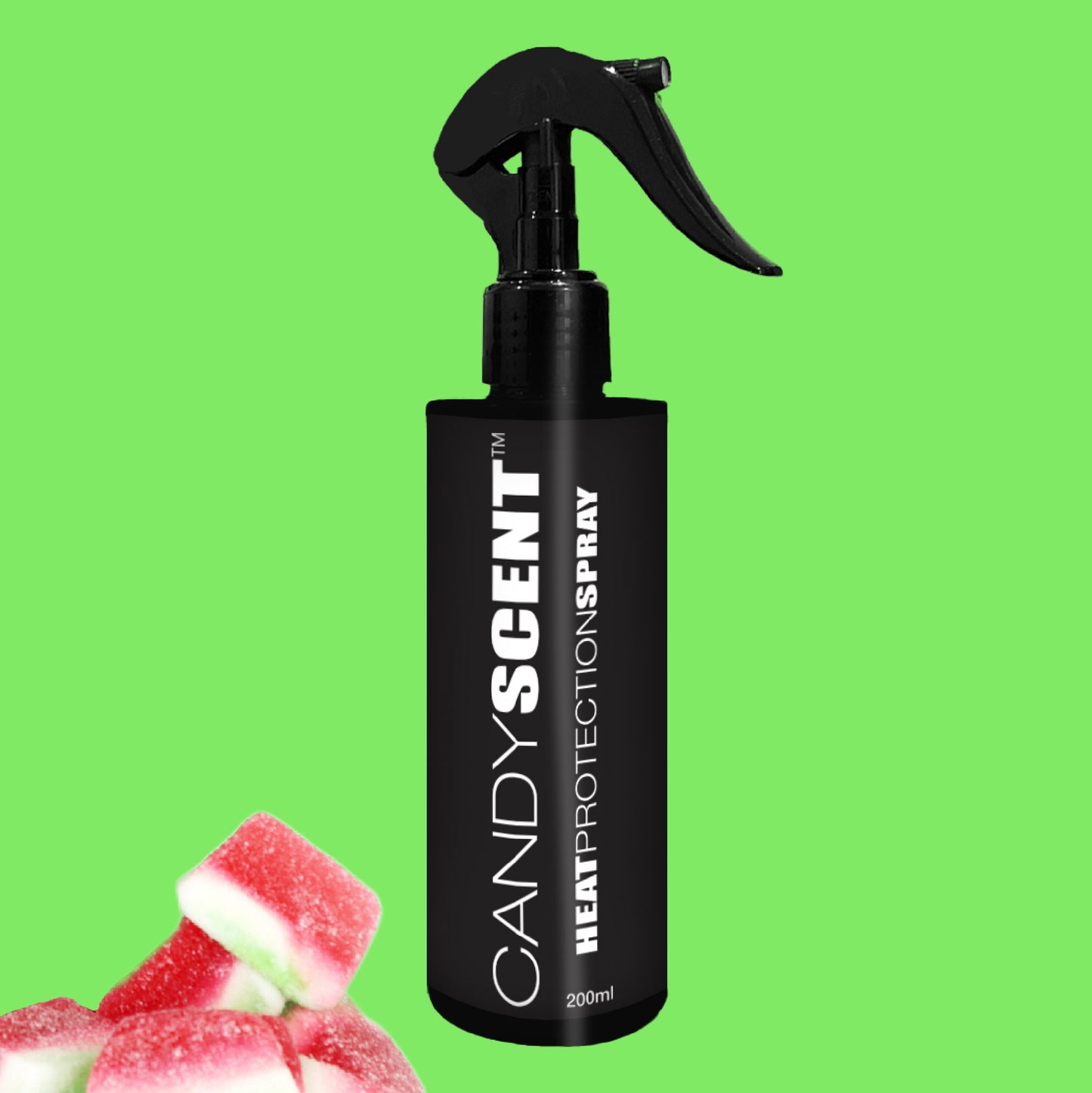 A black bottle of CANDYSCENT™ Heat Protection Spray featuring a trigger nozzle is placed against a vibrant green backdrop. In the bottom left corner, several pieces of red and white candy lend charm, suggesting its delightful fragrance while offering salon-quality results and hair strengthening benefits.