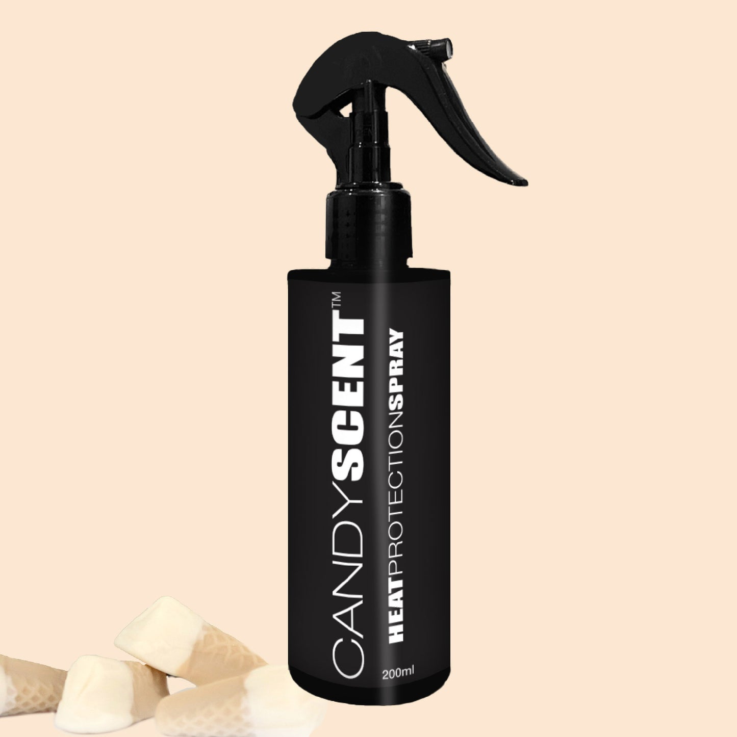 A black spray bottle labeled "Heat Protection Spray, 200ml" from CANDYSCENT™ is positioned upright with a trigger nozzle. Set against the beige background, a few wrapped candies are placed in the bottom left corner, suggesting its salon-quality results for hair strengthening.