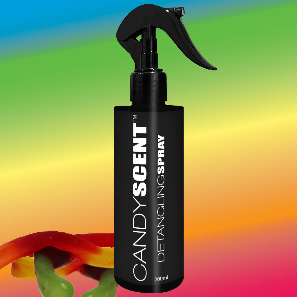 A black 200ml bottle of CANDYSCENT™ Hair Detangling Spray, featuring a trigger spray nozzle, is showcased against a vibrant gradient background. Enriched with aloe vera and jojoba oil, it guarantees smooth, tangle-free hair. Two gummy candies—one red and one green—are positioned in the bottom left corner of the image.