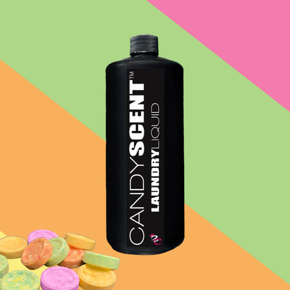 A black bottle labeled "CANDYSCENT™ Laundry Liquid" stands proudly against a vibrant, diagonal striped background. At the bottom left corner, a small pile of pastel-colored candy discs adds charm. This eco-friendly formula ensures your laundry is not only fresh but also biodegradable.