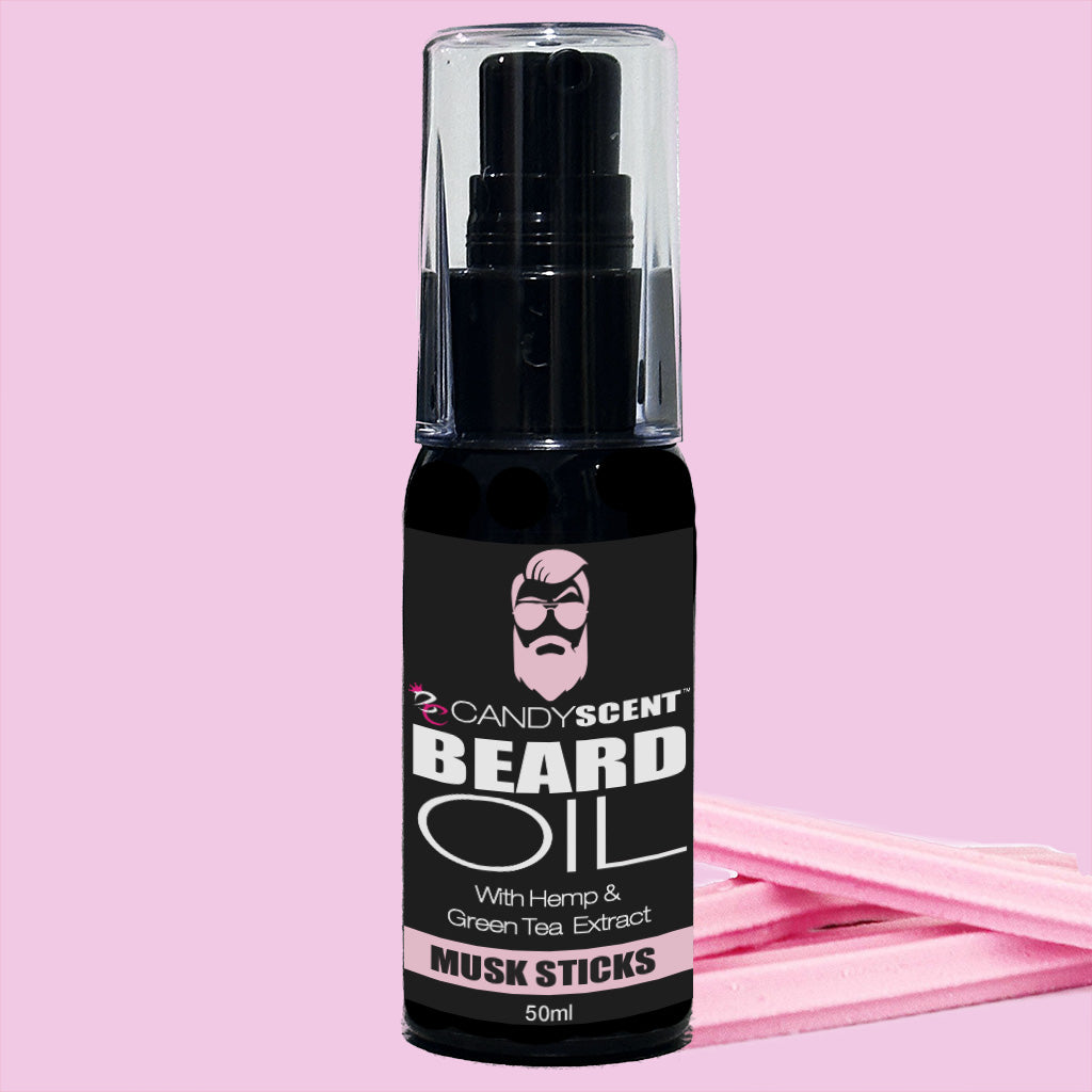 A small black bottle of Beard Oil from CANDYSCENT™, labeled "CANDY SCENT BEARD OIL with Hemp & Green Tea Extract - Musk Sticks" (50ml), is perfect for beard health. The bottle, essential for grooming, features a clear cap and is set against a pink background with light pink candy sticks partially visible at the bottom.