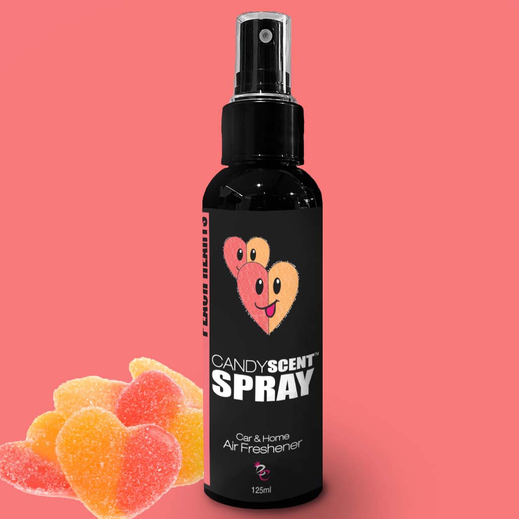 A CANDYSCENT™ Car & Home Scent Spray air freshener in a sleek black bottle with a convenient spray nozzle. The label features two adorable heart-shaped candy characters against a pink background, with heart-shaped gummy candies beside the bottle, designed to eliminate odors and provide a long-lasting fragrance.