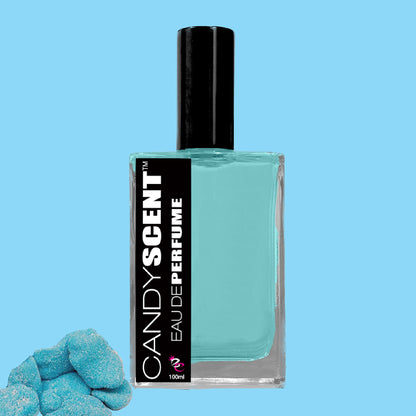 A clear glass bottle with a black cap labeled "CANDYSCENT™ Eau De Perfume / Cologne" containing light blue liquid sits against a solid light blue background. In the bottom left corner, there are some sugary treats, particularly blue sugar-coated gummy candies.