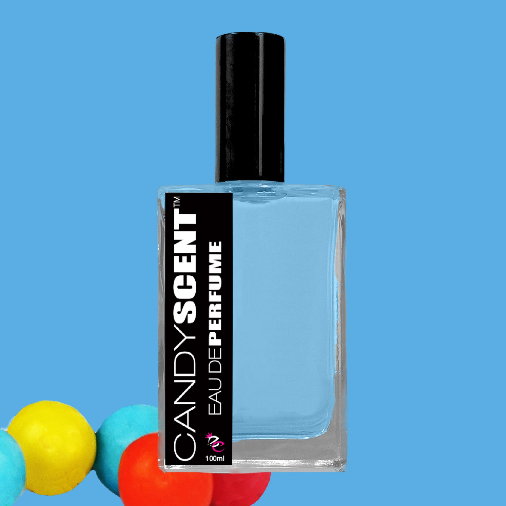 A bottle of CANDYSCENT™ Eau De Perfume / Cologne features sweet, playful fragrances. The rectangular bottle has a black cap and contains light blue liquid. Its label is black with white text, and the bottom left corner displays colorful spherical objects in yellow, orange, and blue that evoke sugary treats.