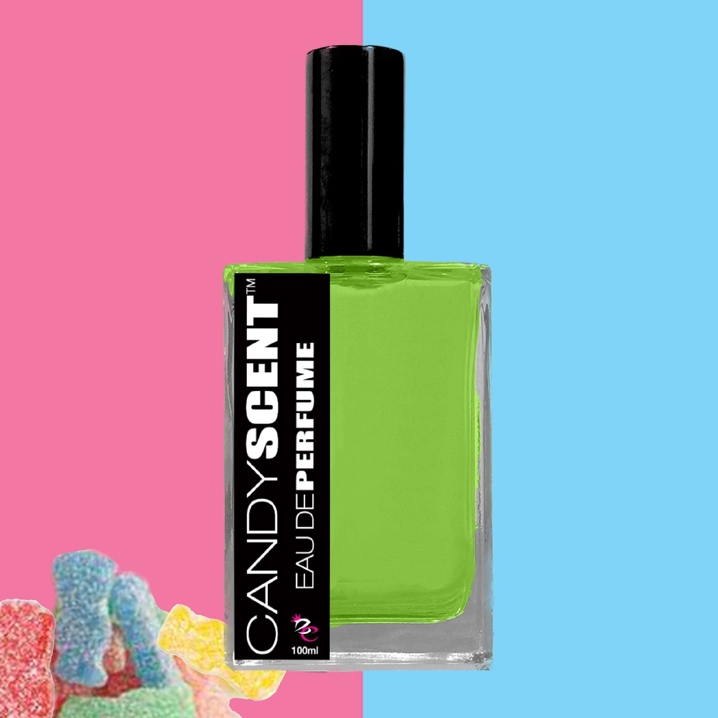 A bottle of CANDYSCENT™ Eau De Perfume / Cologne with a black rectangular label is displayed against a split pink and blue background. Next to the bottle are colorful gummy candy pieces. The perfume, perfect for everyday wear, is in a clear glass bottle filled with green liquid and has a black cap.