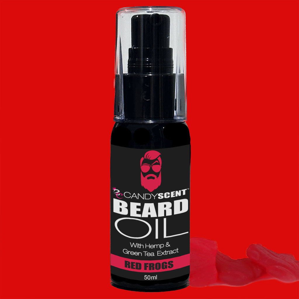 A black 50ml bottle of CANDYSCENT™ Beard Oil set against a red background. The label shows a red bearded icon and mentions that the product includes hemp and green tea extract. The scent is "Red Frogs." Red gummy candies are arranged next to the bottle, highlighting the beard health benefits in your grooming essentials.