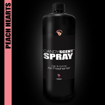 A 1000ml black bottle of CANDYSCENT™ Car & Home Scent Sprays boasts a "Peach Hearts" label on a pink side banner, offering a sweet and long-lasting aroma perfect for use in cars and homes, set against a dark background.