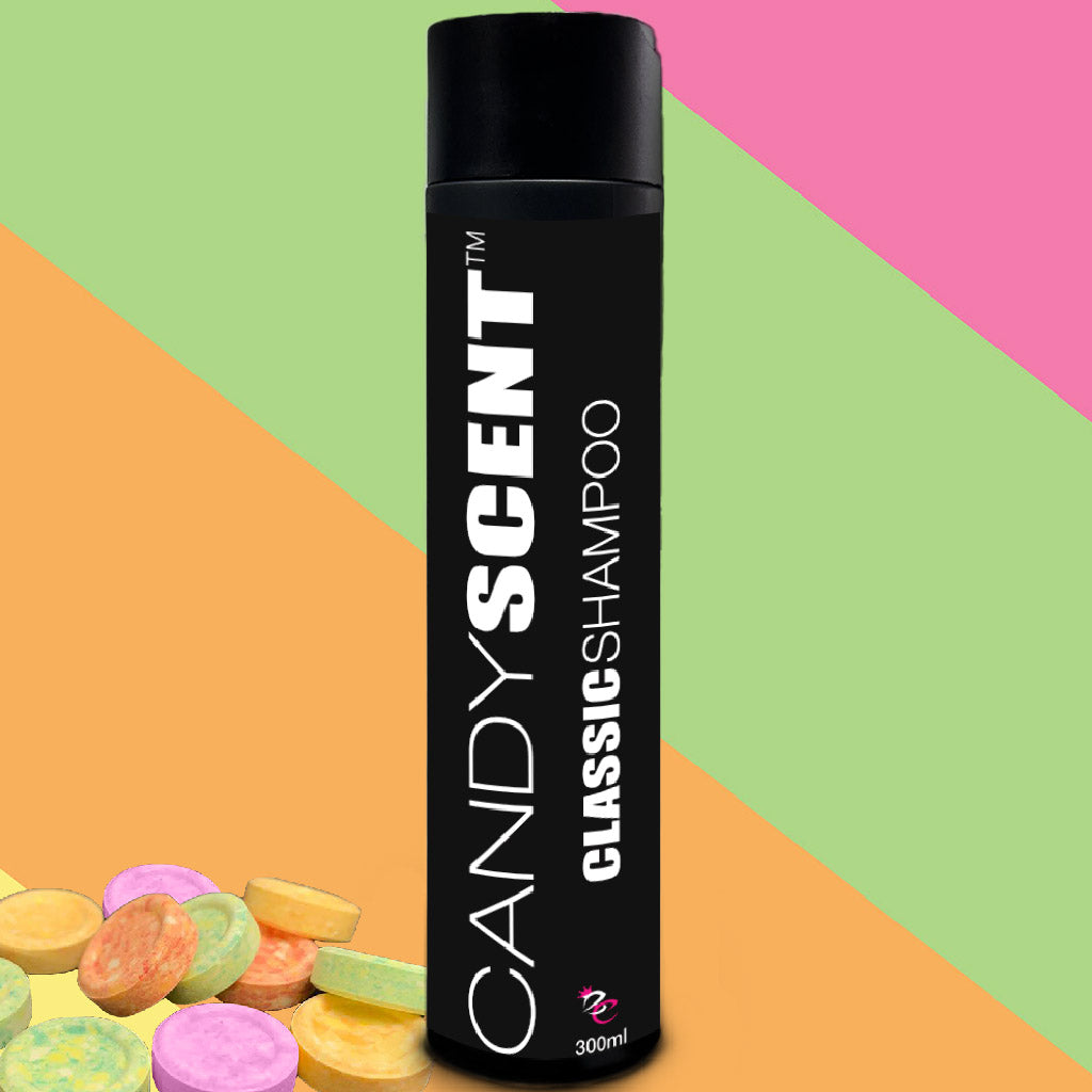 A black cylindrical bottle labeled "Classic Shampoo" from the brand CANDYSCENT™ stands upright on a colorful background featuring diagonal stripes of green, pink, and orange. Round, candy-like objects are placed in the bottom left corner. The luxurious 300 ml shampoo bottle is perfect for your hair care routine.